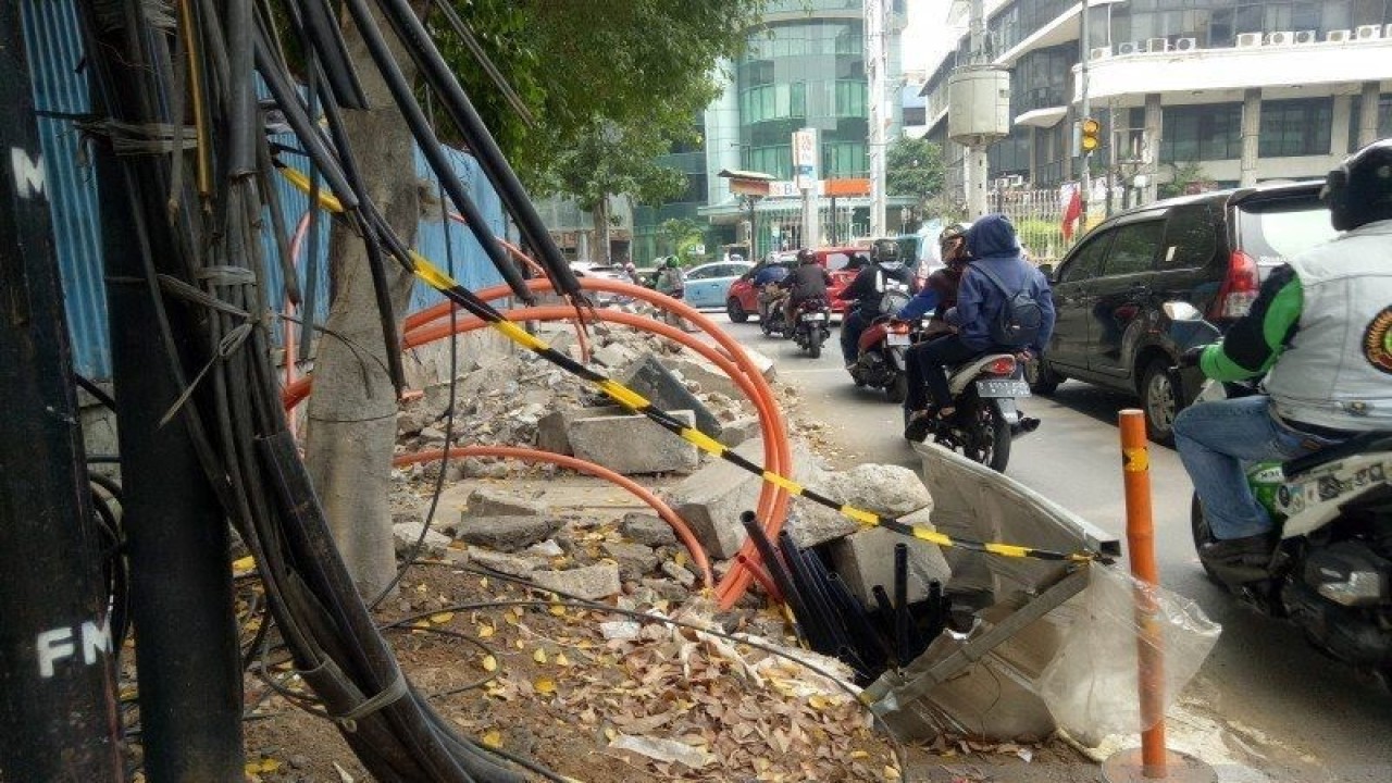 Pekerjaan jaringan kabel bawah tanah yang memakan jalur pejalan kaki terlihat berantakan tanpa pita pengaman yang memadai di kawasan Cikini Jakarta Pusat, Senin (4-10-2019). Dok ANTARA)
