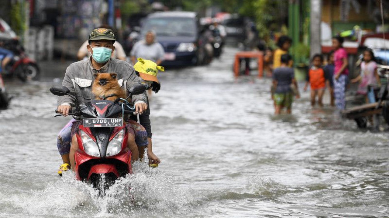 Ilustrasi warga mengendarai sepeda motor melintasi banjir yang menggenangi kawasan Semper Barat, Jakarta Utara, Minggu (1/1/2023). . ANTARA FOTO/M Risyal Hidayat/rwa.