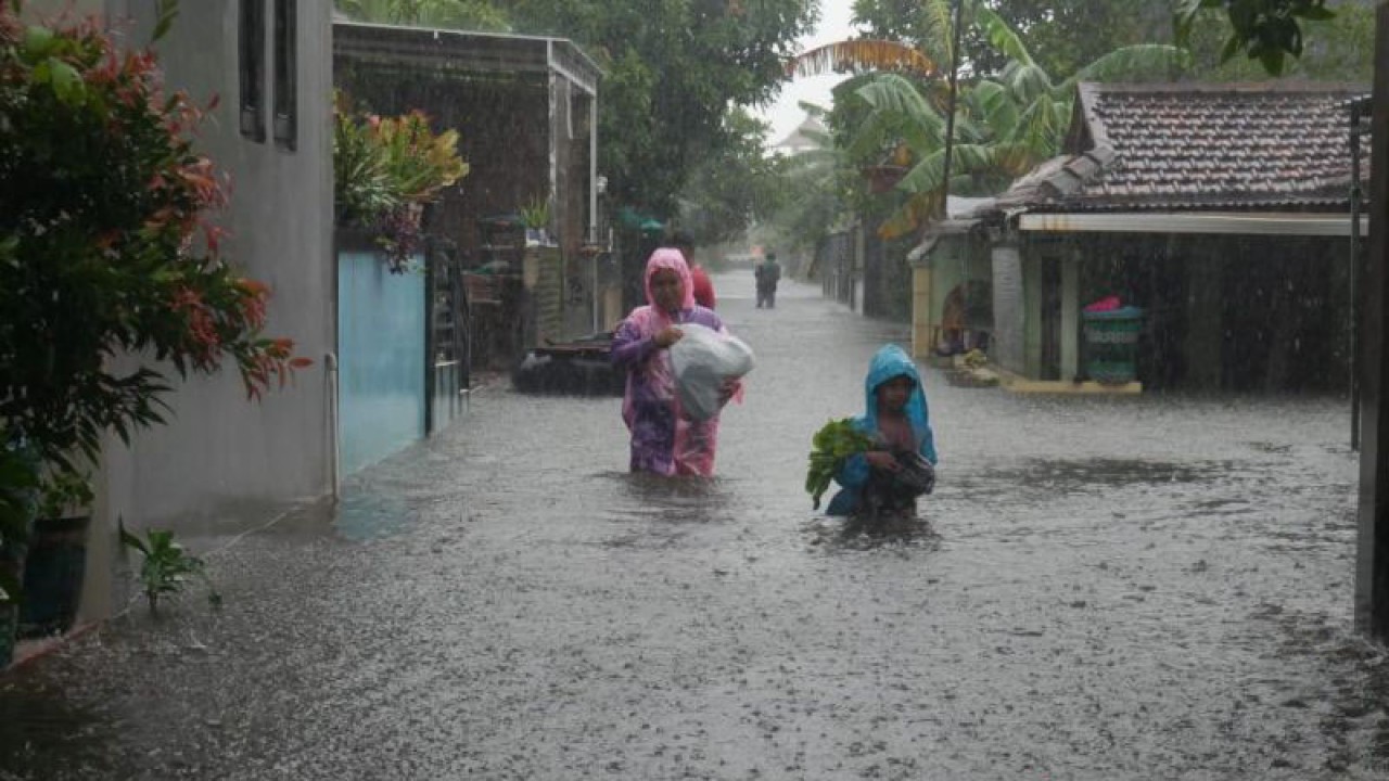 Sejumlah warga tengah melintasi genangan banjir yang terjadi di Kabupaten Kudus, Jawa Tengah, beberapa waktu lalu. (ANTARA/Akhmad Nazaruddin Lathif)