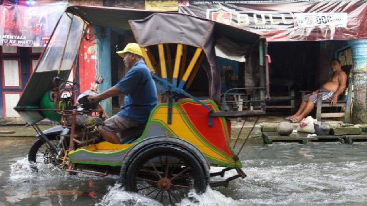 Warga melintasi genangan air akibat banjir rob di Bagan Deli, Belawan, Kota Medan, Sumatera Utara, Selasa (25/10/2022). Badan Penanggulangan Bencana Daerah (BPBD) Kota Medan mencatat banjir yang dipicu oleh pasang air laut tersebut telah berdampak di enam kelurahan, seperti BelawanI, Belawan II, Sicanang, Bahari, Bahagia dan Bagan Deli. (Dok ANTARA)