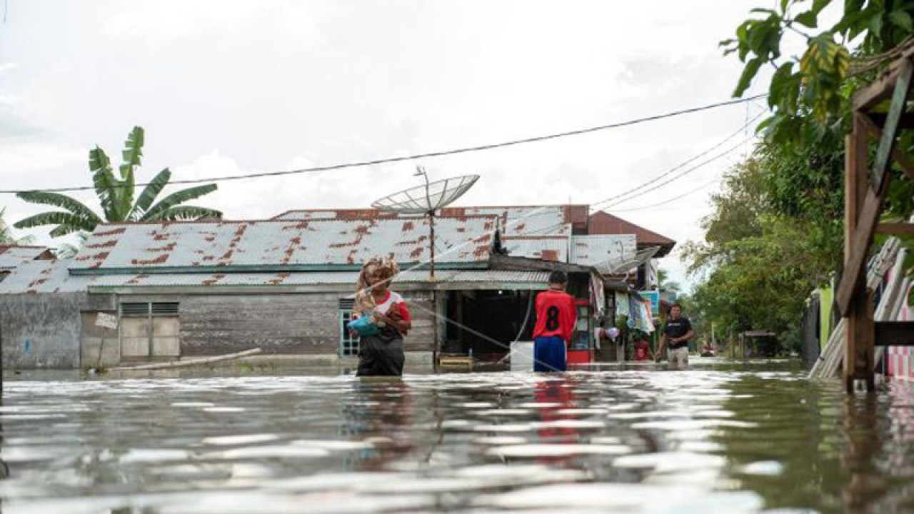 Sejumlah warga melintasi banjir yang melanda Kampung Tibang, Kecamatan Pidie, Kabupaten Pidie, Aceh, Ahad (22/1/2023). Banjir disebabkan tingginya intensitas hujan di kawasan tersebut dan buruknya drainase. (ANTARA FOTO/Joni Saputra/Lmo)