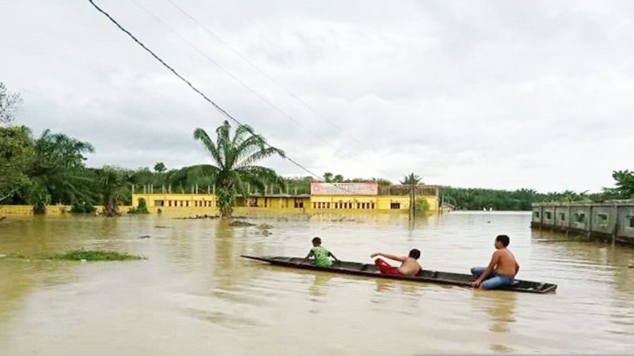 Sejumlah anak menaiki sampan dayung di depan Kampus STAI Aceh Tamiang di Karang Baru yang tergenang banjir, Minggu (22/1/2023). ANTARA/Dede Harison
