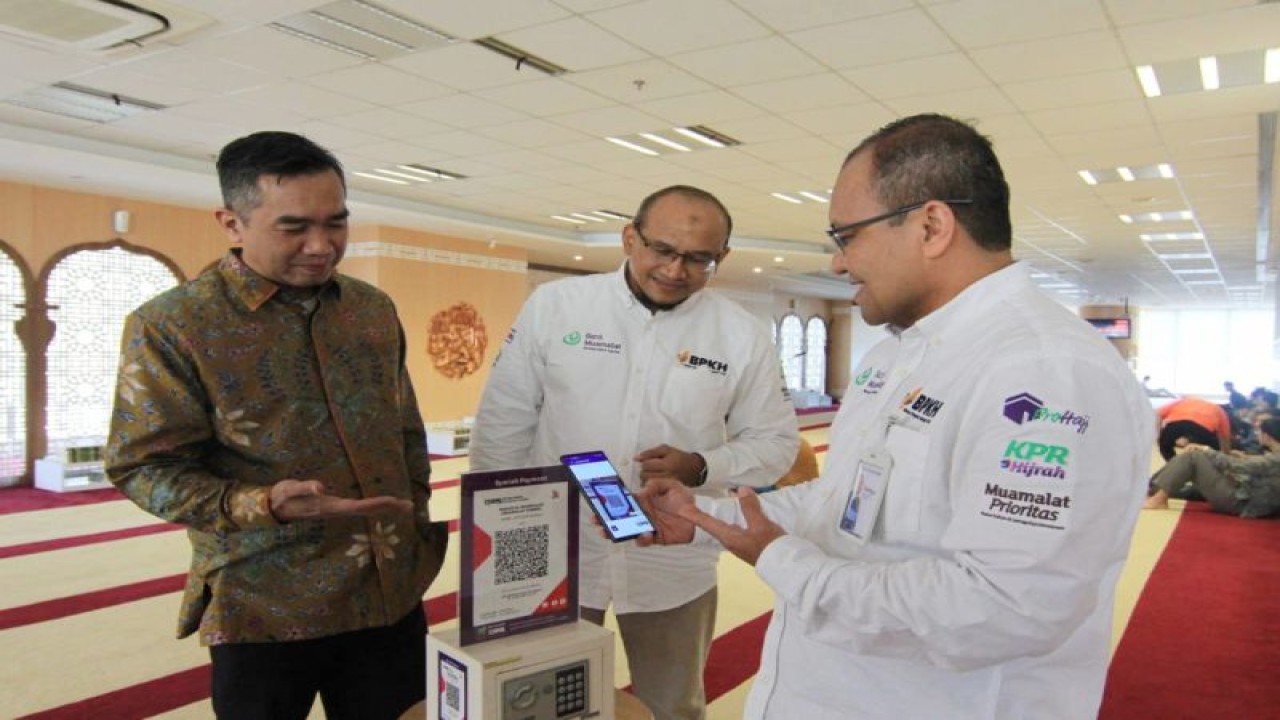Direktur Operasi PT Bank Muamalat Indonesia Tbk Wahyu Avianto (kanan) didampingi oleh Direktur Kepatuhan Karno (kiri) dan Chief Human Capital Officer Riksa Prakoso (tengah) melakukan donasi menggunakan fitur QR Code pada aplikasi Muamalat DIN di kotak amal Masjid Al-Muamalah, Muamalat Tower, Jakarta, Kamis, (Bank Muamalat)