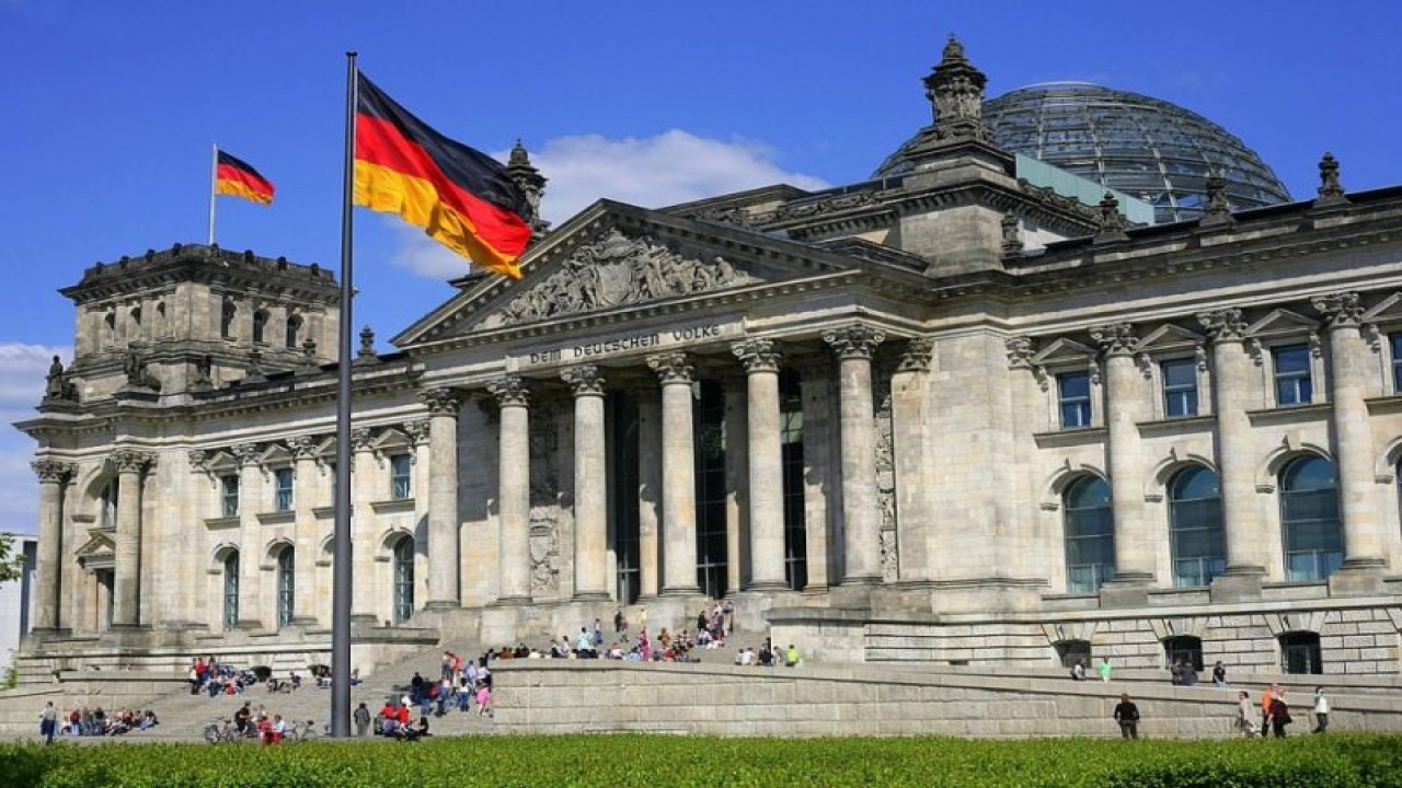 Bendera Jerman terlihat di depan gedung Reichstag di Berlin, Jerman, 3 Oktober 1990. (Wikimedia/Cezary Piwowarski)