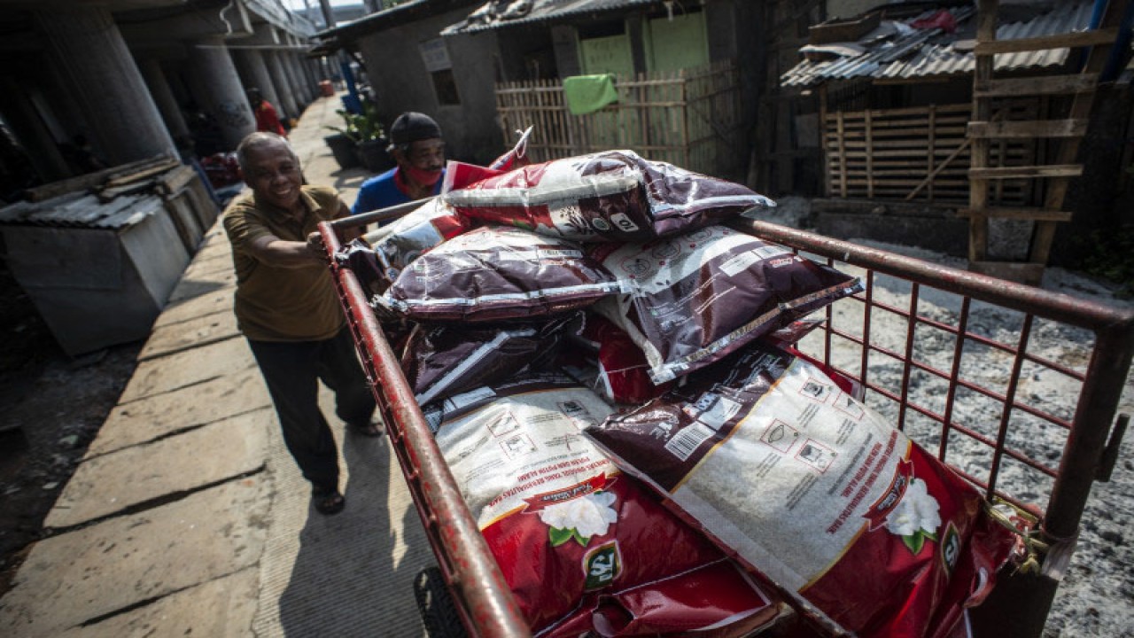 Pengurus RT mengangkut bantuan sosial non tunai berupa beras yang siap disalurkan kepada warga di kawasan RW 02 Kelurahan Cakung Barat, Jakarta, Kamis (29/7/2021). ANTARA FOTO/Aprillio Akbar/aww.