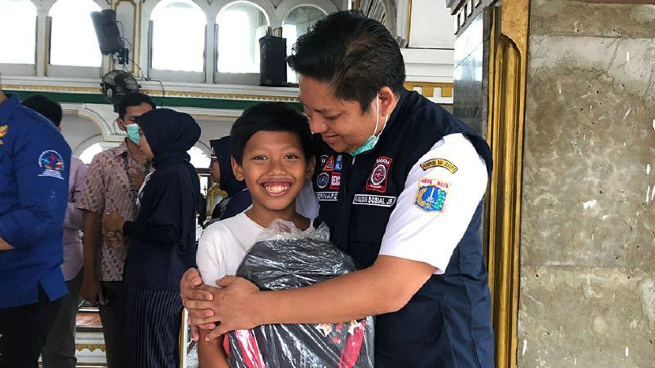 Kepala Suku Dinas Sosial Jakarta Selatan Bernard Tambunan menghibur salah satu anak di pengungsian untuk kembali ceria, Jakarta, Rabu (28/12/2022). ANTARA/HO-Suku Dinas Sosial Jakarta Selatan/aa.