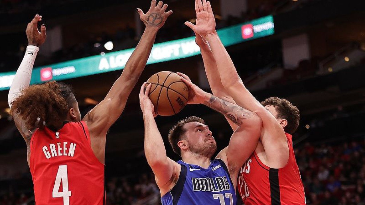 Bintang Dallas Mavericks Luka Doncic (tengah) berusaha menerobos kepungan dua pemain Houston Rockets, Jalen Green (kiri) dan Alperen Sengun, demi mencetak angka dalam gim lanjutan NBA di Toyota Center, Texas, Amerika Serikat, Senin (2/1/2023) waktu setempat. (ANTARA/AFP/GETTY IMAGES/Bob Levey)