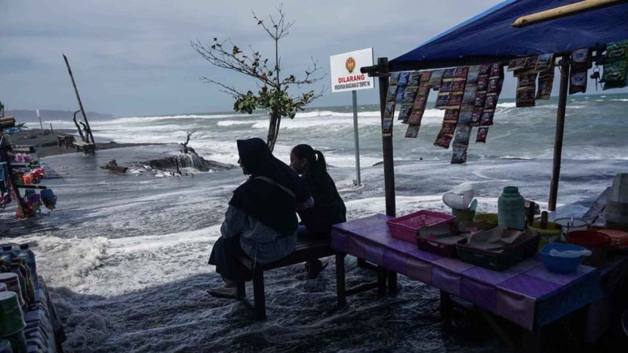 Pengunjung berada di warung makan yang diterjang gelombang tinggi di Pantai Depok, Bantul, DI Yogyakarta, Minggu (17/7/2022). Badan Meteorologi, Klimatologi dan Geofisika (BMKG) mengeluarkan peringatan dini adanya gelombang tinggi yang mencapai enam meter di selatan Pulau Jawa. ANTARA FOTO/Hendra Nurdiyansyah/rwa.