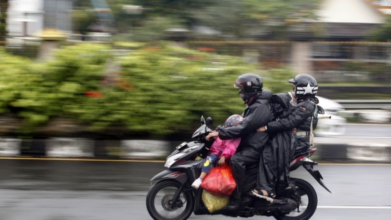 Pengendara sepeda motor mengenakan jas hujan saat melintas di jalur wisata Puncak, Gadog, Kabupaten Bogor, Jawa Barat, Sabtu (31/12/2022). ANTARA FOTO/Yulius Satria Wijaya/aww. (ANTARA FOTO/YULIUS SATRIA WIJAYA)