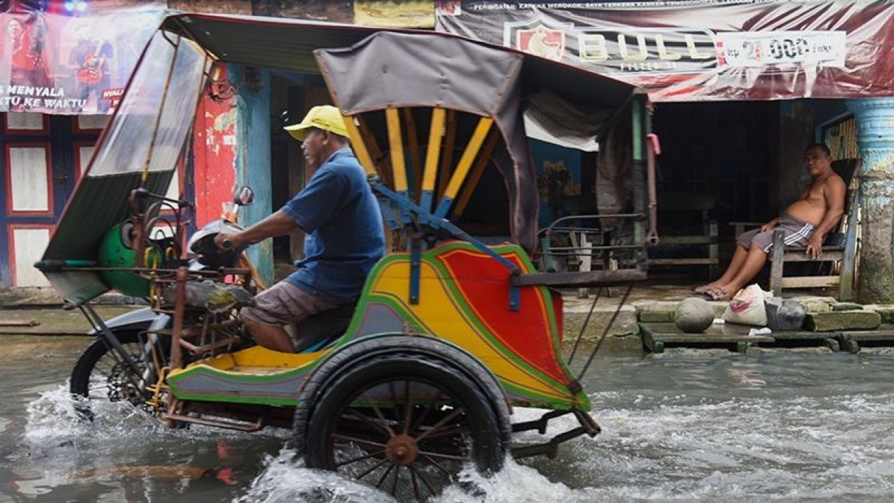 Arsip foto - Warga melintasi genangan air akibat banjir rob di Bagan Deli, Belawan, Kota Medan, Sumatera Utara, Selasa (25/10/2022). ANTARA FOTO/Fransisco Carolio/foc/aa. (ANTARA FOTO/FransiscoCarollio)