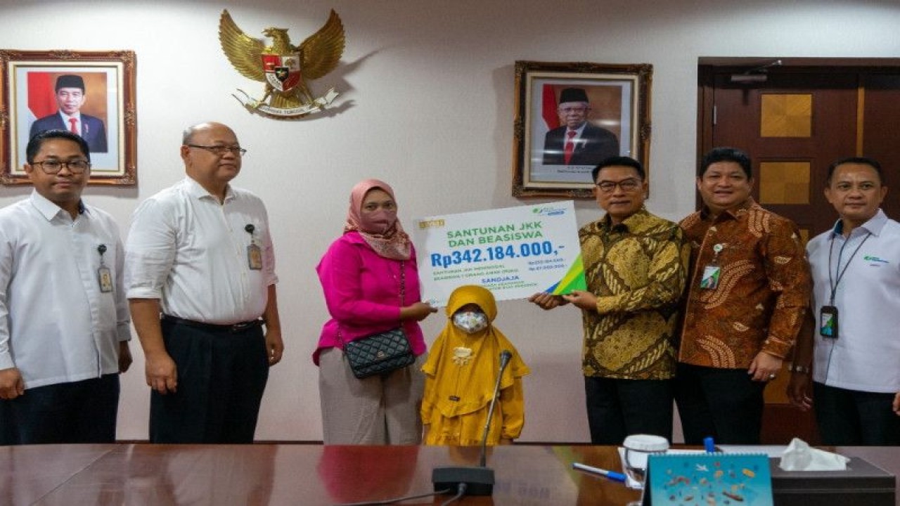 Kepala Staf Kepresidenan Moeldoko didampingi Direktur Kepesertaan BPJS Ketenagakerjaan Zainudin di Jakarta, Senin (16/1/2023), menyerahkan santunan kematian kepada ahli waris almarhum Sandjaja, selaku tenaga pengamanan kantor sekretariat KSP yang meninggal dunia saat bertugas tahun lalu. (ANTARA/HO-KSP)