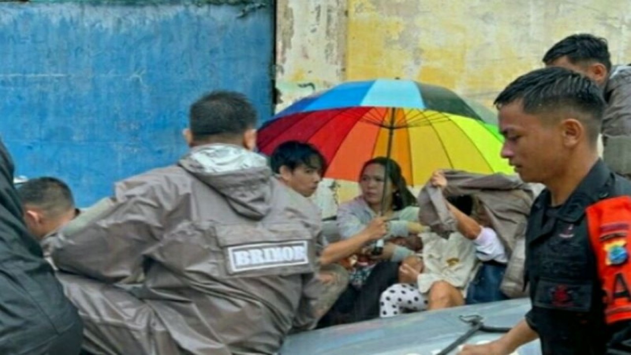 Personel Brimob saat mengevakuasi korban bencana banjir. ANTARA/HO-Humas Polda Sulut (1)