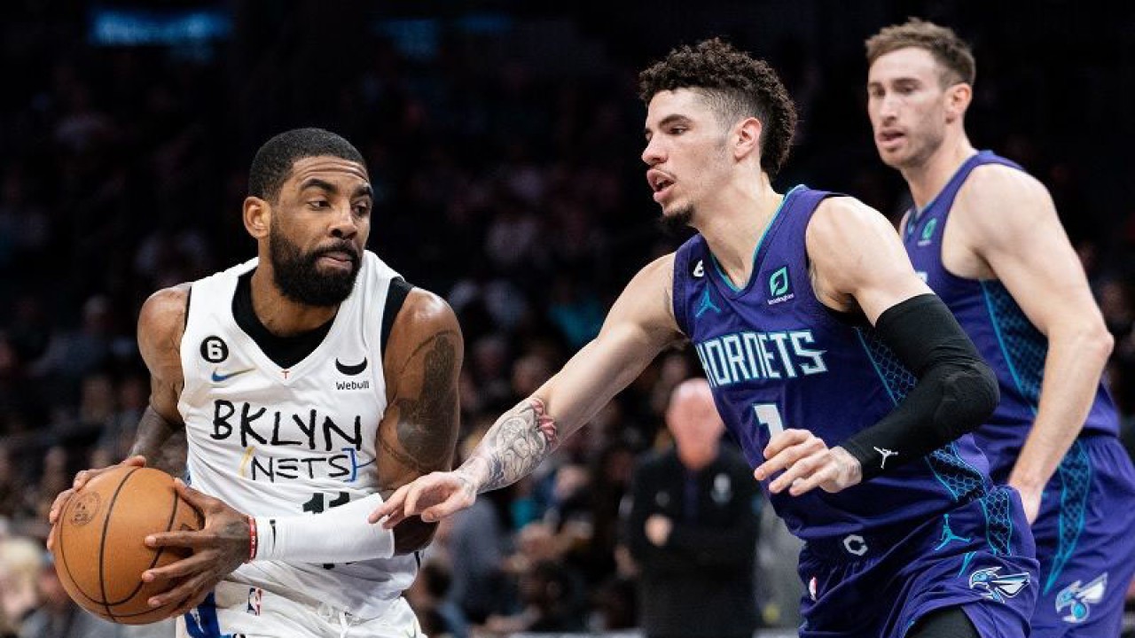 Bintang Brooklyn Nets Kyrie Ivring (kiri) berusaha melewati hadangan bintang Charlotte Hornets LaMelo Ball dalam gim lanjutan NBA di Spectrum Center, Carolina Utara, Amerika Serikat, Sabtu (31/12/2022) waktu setempat. (ANTARA/AFP/GETTY IMAGES/Jacob Kupferman)