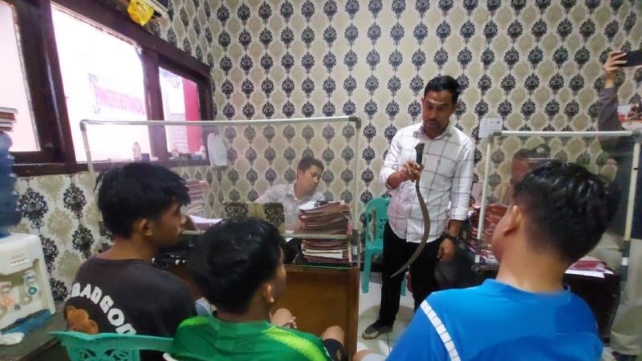 Kepala Unit Reserse Kriminal Kepolisian Sektor Ilir Barat 1 Palembang, Iptu Apriansyah menunjukkan barang bukti senjata tajam jenis celurit di hadapan tiga tersangka tawuran yang menewaskan seorang remaja di Jalan Demang Lebar Daun, Palembang, Sumatera Selatan, Senin (16/1/2023). ANTARA/M Riezko Bima Elko P