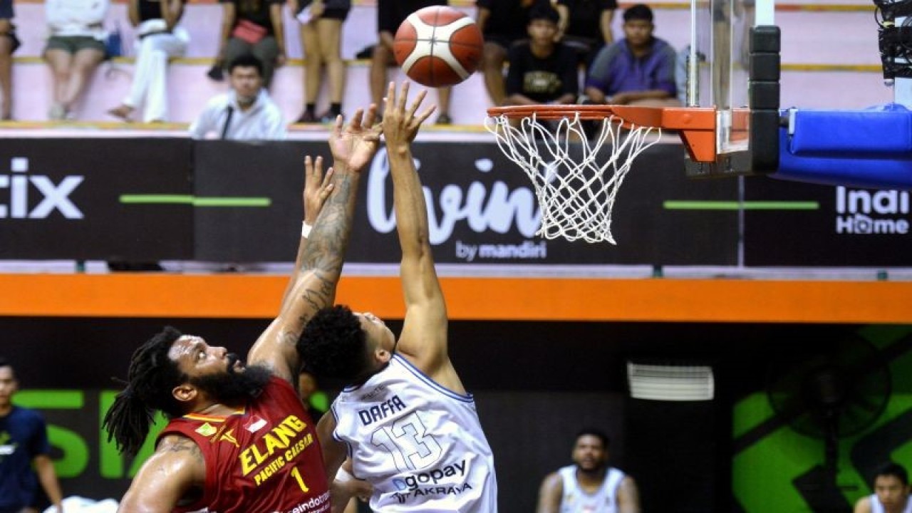 Pebasket Bumi Borneo Basketball Pontianak Muhammad Rizky Ari Daffa (kanan) berusaha memasukkan bola yang dihadang pebasket Elang Pacific Caesar Surabaya Khapri Dean Alston (kiri) saat pertandingan Indonesian Basketball League (IBL) 2023 di GOR Merpati, Denpasar, Bali, Selasa (17/1/2023). ANTARA FOTO/Fikri Yusuf/nym. (ANTARA FOTO/FIKRI YUSUF)