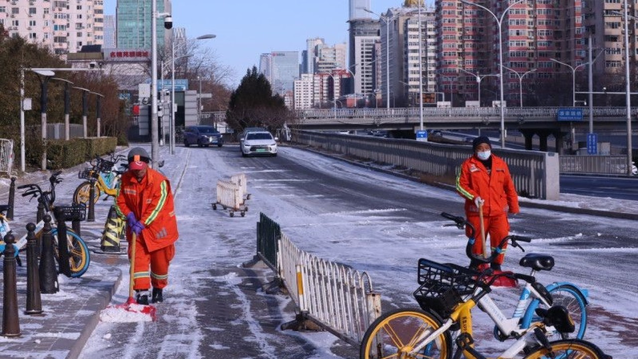 Petugas membersihkan salju yang menutupi permukaan jalan di ring road 3 Kota Beijing, China, Senin (23/1/2022). (ANTARA/M. Irfan Ilmie)