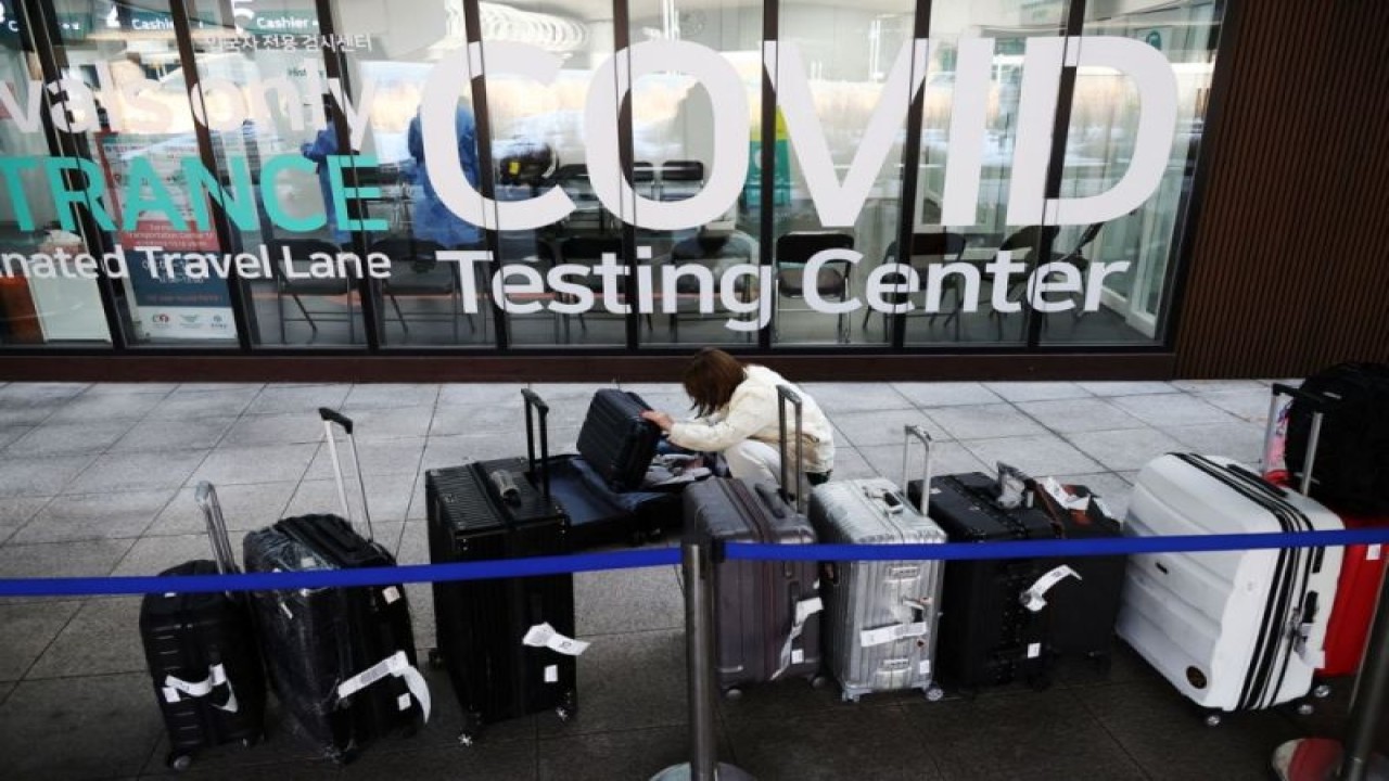 Seorang pengunjung dari China memeriksa barang bawaannya sambil menunggu hasil tes COVID-19 setibanya di Bandara Internasional Incheon di Incheon, Korea Selatan, 4 Januari 2023. ANTARA/REUTERS/Kim Hong-Ji/as