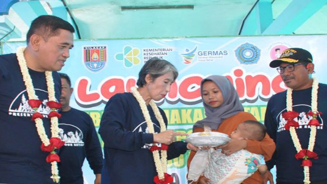 Kepala Dinas Kesehatan Provinsi Jawa Tengah yang juga Penjabat Bupati Cilacap Yunita Dyah Suminar (dua dari kiri) memberikan paket makanan tambahanan kepada ibu seorang balita pada acara peluncuran Pemberian Makanan Tambahan (PMT) Bagi Bayi Berpotensi Stunting dan Ibu Hamil Kekurangan Energi Kronik di Balai Desa CItepus, Kecamatan Jeruklegi, Cilacap, Senin (16/1/2023). ANTARA/HO-Dinkominfo Cilacap