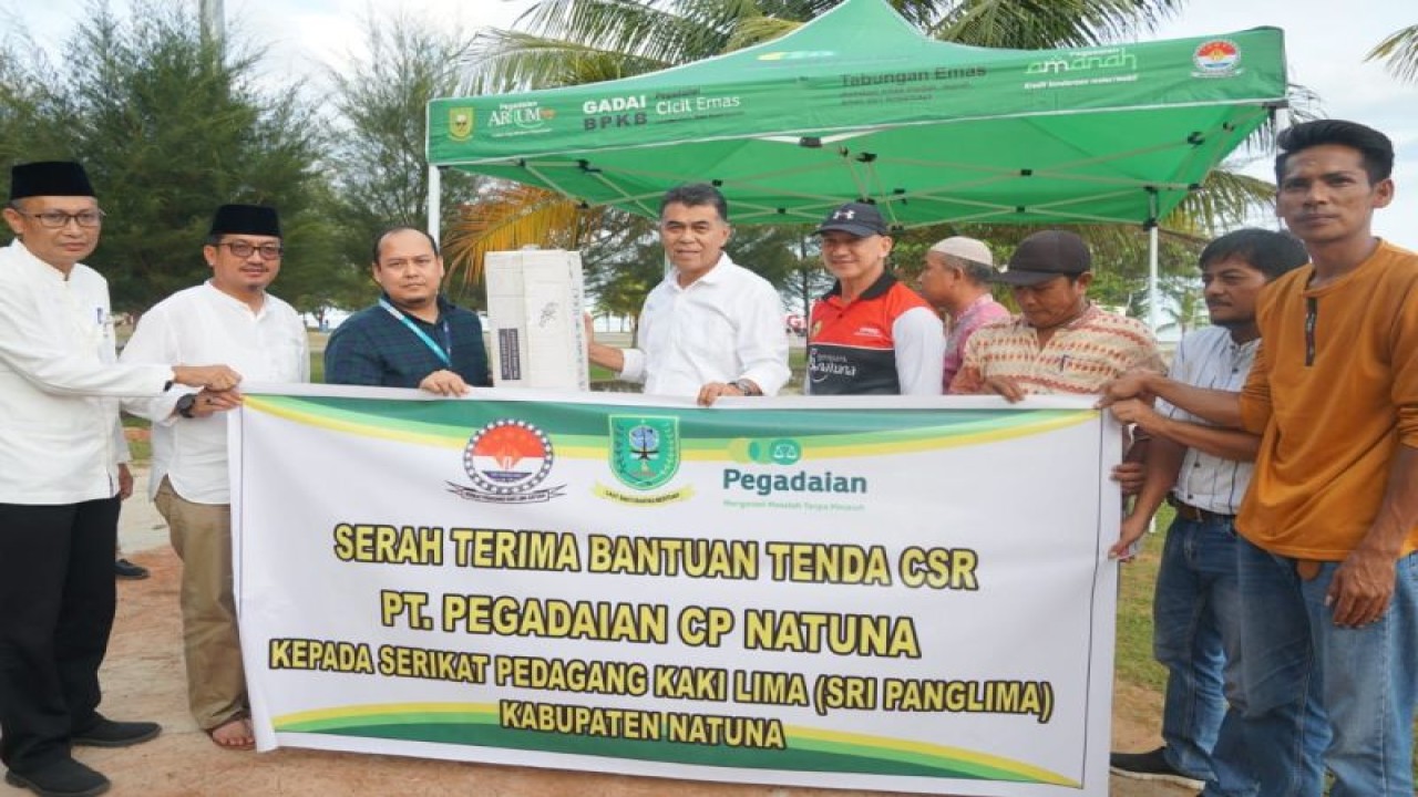 Bupati Natuna Wan Siswandi ​​​​​​​saat menyerahkan bantuan tenda pedagang kali lima CSR Pengadaian Natuna, di Pantai Piwang Natuna, Kepri, Jumat (13/1/2023). (ANTARA/HO-Kominfo Natuna)