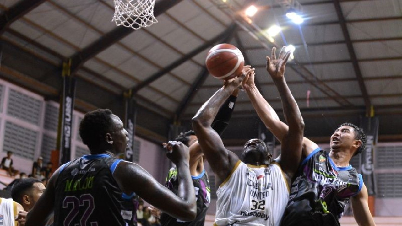 Pebasket Dewa United Banten Anthony Johnson (kedua kanan) berusaha memasukkan bola yang dihadang pebasket RJ Amartha Hangtuah Jakarta Stefan Carsera (kanan), Gunawan (kedua kiri) dan Emmanuel Martin Malou (kiri) saat pertandingan Indonesian Basketball League (IBL) 2023 di GOR Merpati, Denpasar, Bali, Rabu (18/1/2023). . ANTARA FOTO/Fikri Yusuf/foc. (ANTARA FOTO/FIKRI YUSUF)