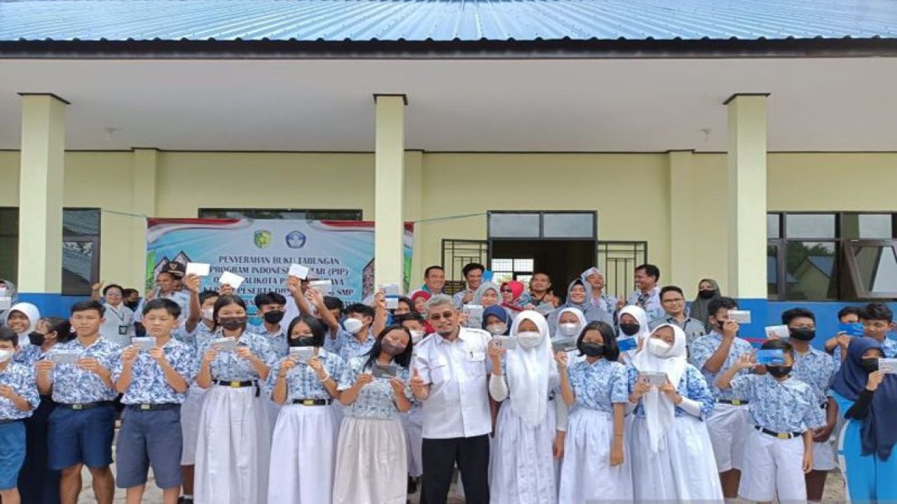 Kepala Disdik Kota Palangka Raya, Kalimantan Tengah Jayani berfoto bersama peserta didik yang menerima bantuan tunai melalui PIP yang dilaksanakan di halaman SMP Negeri 16 Palangka Raya, Rabu (11/1/2023). ANTARA/Adi WIbowo