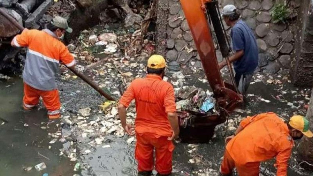 Petugas Dinas Lingkungan Hidup Kabupaten Bekasi, Jawa Barat membersihkan sampah di aliran Sungai Cikarang Hilir, Desa Sukaringin, Kecamatan Sukawangi, Senin (16/1/2023). (FOTO ANTARA/Pradita Kurniawan Syah).
