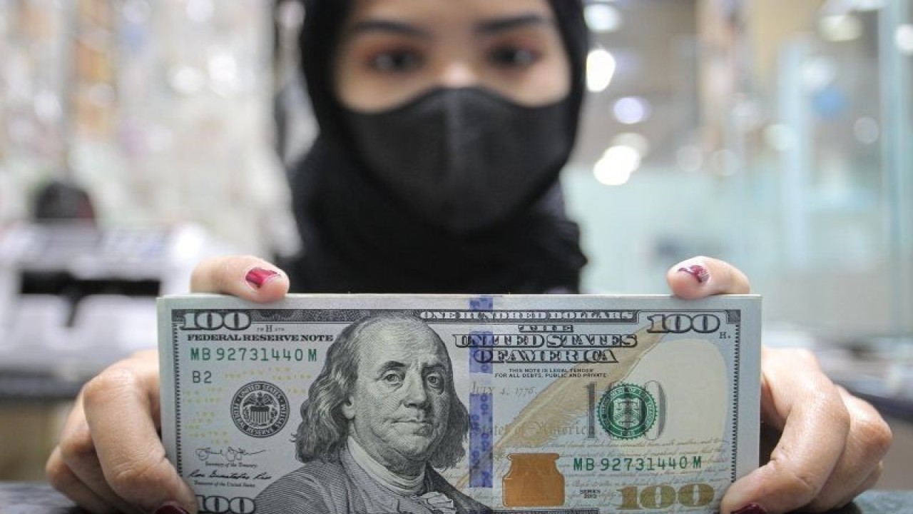 Pekerja menunjukkan uang dolar AS di salah satu gerai penukaran mata uang di Jakarta, Rabu (5/1/2022). Nilai tukar (kurs) rupiah yang ditransaksikan antarbank di Jakarta pada Rabu sore ditutup melemah 58 poin atau 0,41 persen ke posisi Rp14.371 per dolar AS dibandingkan penutupan perdagangan sebelumnya Rp14.313 per dolar AS yang dipicu antisipasi pelaku pasar terhadap pengetatan kebijakan bank sentral Amerika Serikat The Federal Reserve pada tahun ini. ANTARA FOTO/Dhemas Reviyanto/wsj.