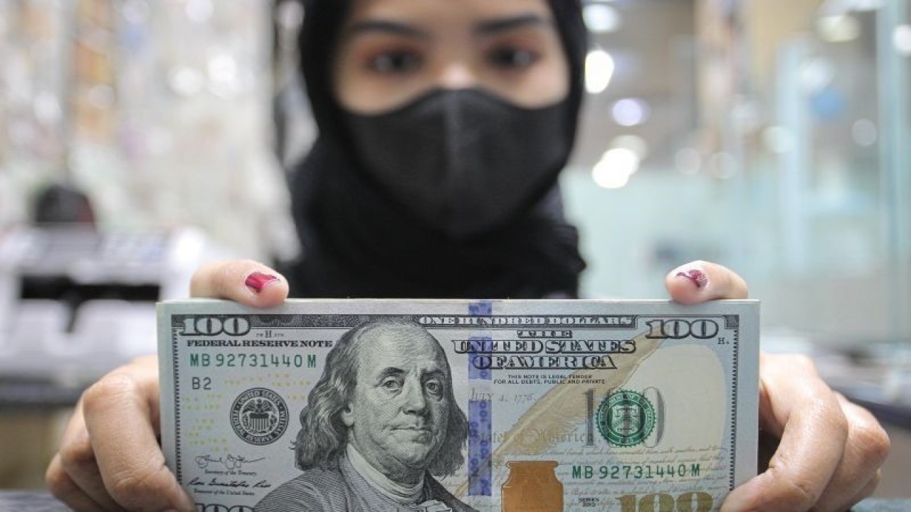 Pekerja menunjukkan uang dolar AS di salah satu gerai penukaran mata uang di Jakarta, Rabu (5/1/2022). Nilai tukar (kurs) rupiah yang ditransaksikan antarbank di Jakarta pada Rabu sore ditutup melemah 58 poin atau 0,41 persen ke posisi Rp14.371 per dolar AS dibandingkan penutupan perdagangan sebelumnya Rp14.313 per dolar AS yang dipicu antisipasi pelaku pasar terhadap pengetatan kebijakan bank sentral Amerika Serikat The Federal Reserve pada tahun ini. (ANTARA FOTO/Dhemas Reviyanto/wsj.)