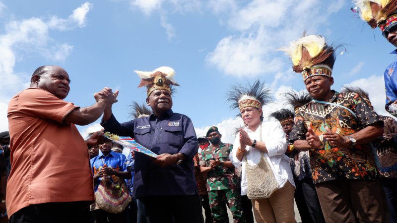 Asisten Bidang Pemerintahan Setda Papua Doren Wakerkwa (kiri) bersamalam dengan Bupati Jayapura Mathius Awoitauw (kedua kiri) saat penyerahan kodefikasi 14 kampung (desa) adat di Lapangan Apel kantor Bupati Jayapura, Jayapura, Papua, Jumat (19-8-2022). Kodefikasi atau penataan kampung (desa) adat tersebut diharapkan dapat mewujudkan penyelenggara pemerintah desa, menpercepat peningkatan kesejahteraan masyarakat desa, mempercepat peningkatan kualitas pelayanan publik dan meningkatkan daya saing desa. ANTARA FOTO/Sakti Karuru/YU/hp.