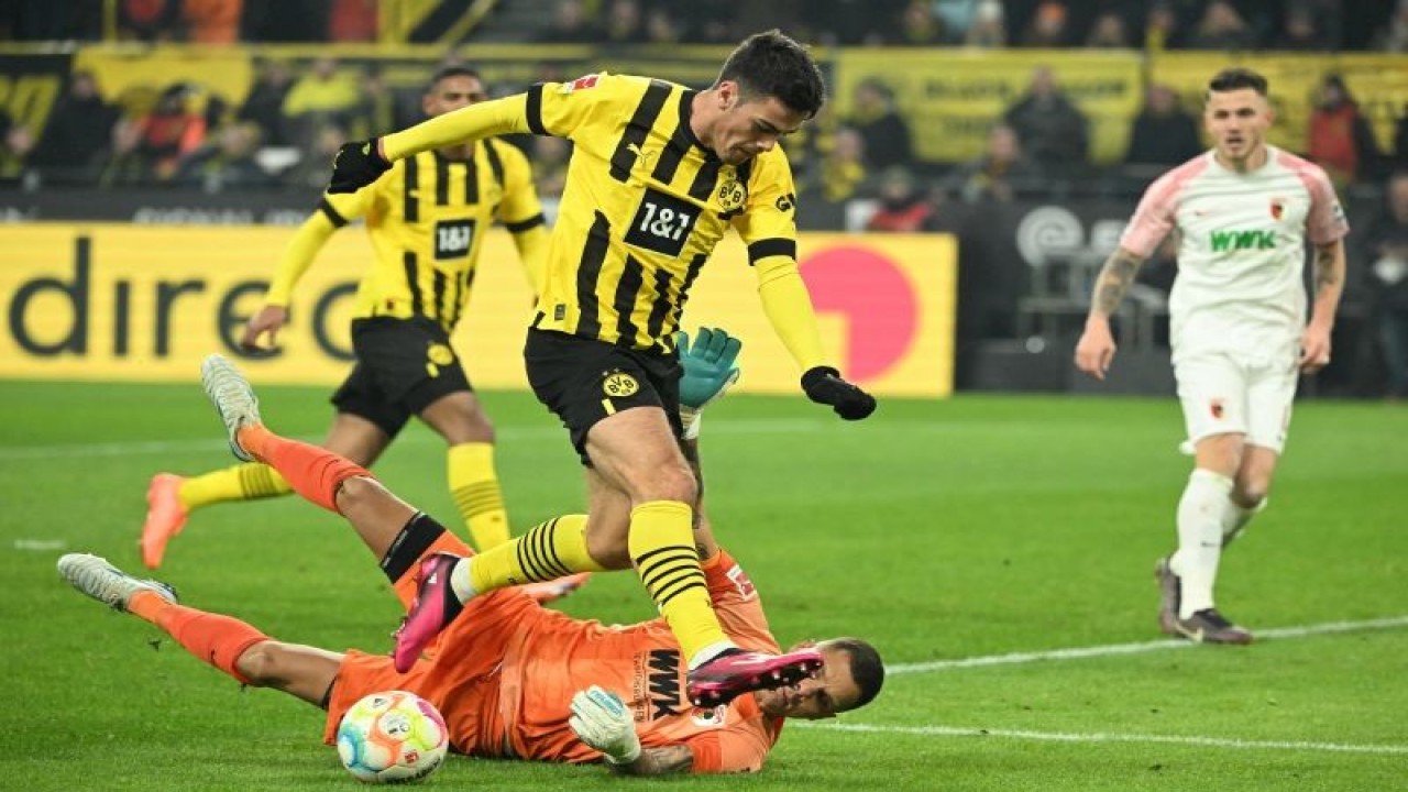 Gelandang Borussia Dortmund Giovanni Reyna berusaha menaklukkan kiper Augsburg Rafal Gikiewicz pada pertandingan Liga Jerman yang dimainkan di Signal Iduna Park, Dortmund, Minggu (22/1/2023). (ANTARA/AFP/INA FASSBENDER)