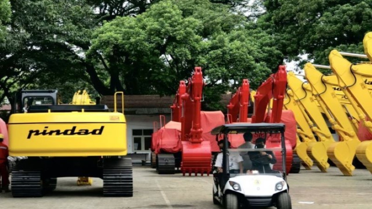 Pegawai PT Pindad (Persero) melewati sejumlah ekskavator buatan PT Pindad di Bandung, Jawa Barat. (ANTARA/Genta Tenri Mawangi)