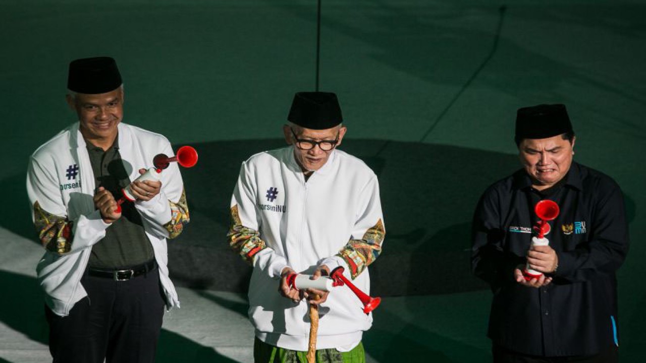 Arsip-Menteri BUMN Erick Thohir (kanan), Rais Aam PBNU Kiai Miftachul Akhyar (tengah), dan Gubernur Jawa Tengah Ganjar Pranowo (kiri) membunyikan terompet saat pembukaan Porseni NU di GOR Sritex Arena, Solo, Jawa Tengah, Senin (16/1/2023). ANTARA FOTO/Mohammad Ayudha/tom.