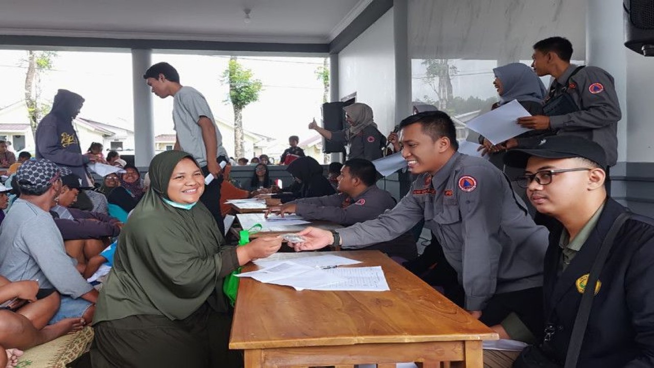 Petugas BPBD memberikan kunci hunian tetap kepada penyintas bencana erupsi Semeru di relokasi Bumi Semeru Damai di Desa Sumbermujur, Kabupaten Lumajang, Rabu (25/1/2023). (ANTARA/HO-Diskominfo Lumajang)