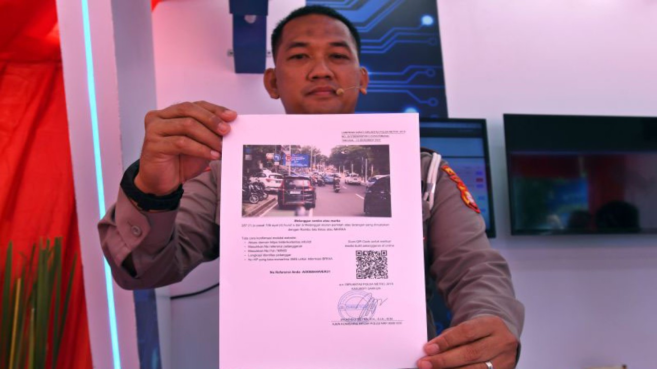 Petugas menunjukkan contoh surat tilang dari sistem tilang elektronik (ETLE) Mobile yang diluncurkan di Mapolda Metro Jaya, Jakarta, Selasa (13/12/2022). Polda Metro Jaya meluncurkan 11 kendaraan patroli khusus yang dilengkapi 'ETLE mobile' untuk bertugas di ruas-ruas jalan raya se-DKI Jakarta dan Tangerang Selatan yang tidak terpasang kamera ETLE statis. ANTARA FOTO/Aditya Pradana Putra/aww.