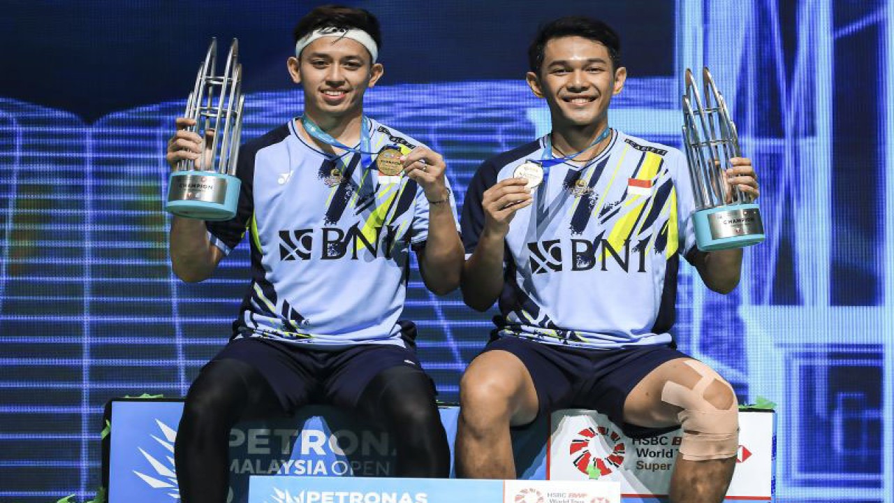 Pebulu tangkis ganda putra Indonesia Fajar Alfian (kanan) bersama Muhammad Rian Ardianto (kiri) berpose dengan trofinya usai meraih juara pertama dalam Malaysia Open 2023 di Axiata Arena, Kuala Lumpur, Malaysia, Minggu (15/1/2023). Fajar Alfian dan Muhammad Rian Ardianto meraih juara pertama dalam Malaysia Open 2023 usai mengalahkan pebulu tangkis ganda putra China Liang Weikeng dan Wang Chang dengan skor 21-18, 18-21, dan 21-13. ANTARA FOTO/HO-PBSI/mrh/nym. (ANTARA FOTO/PBSI)