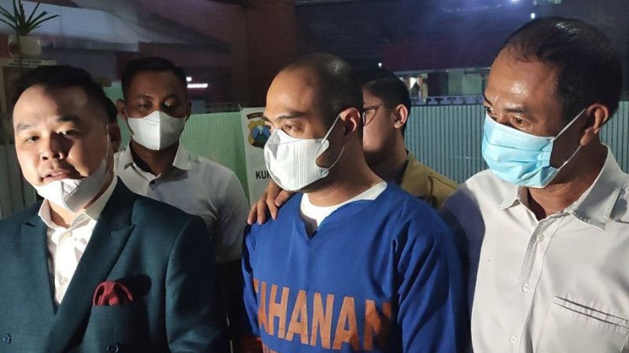 Artis Ferry Irawan (tengah) menggunakan baju tahanan usai ditahan sebagai tersangka kasus KDRT terhadap istrinya Venna Melinda di Mapolda Jatim, Surabaya, Senin (16/1/2023). (ANTARA/Willi Irawan)