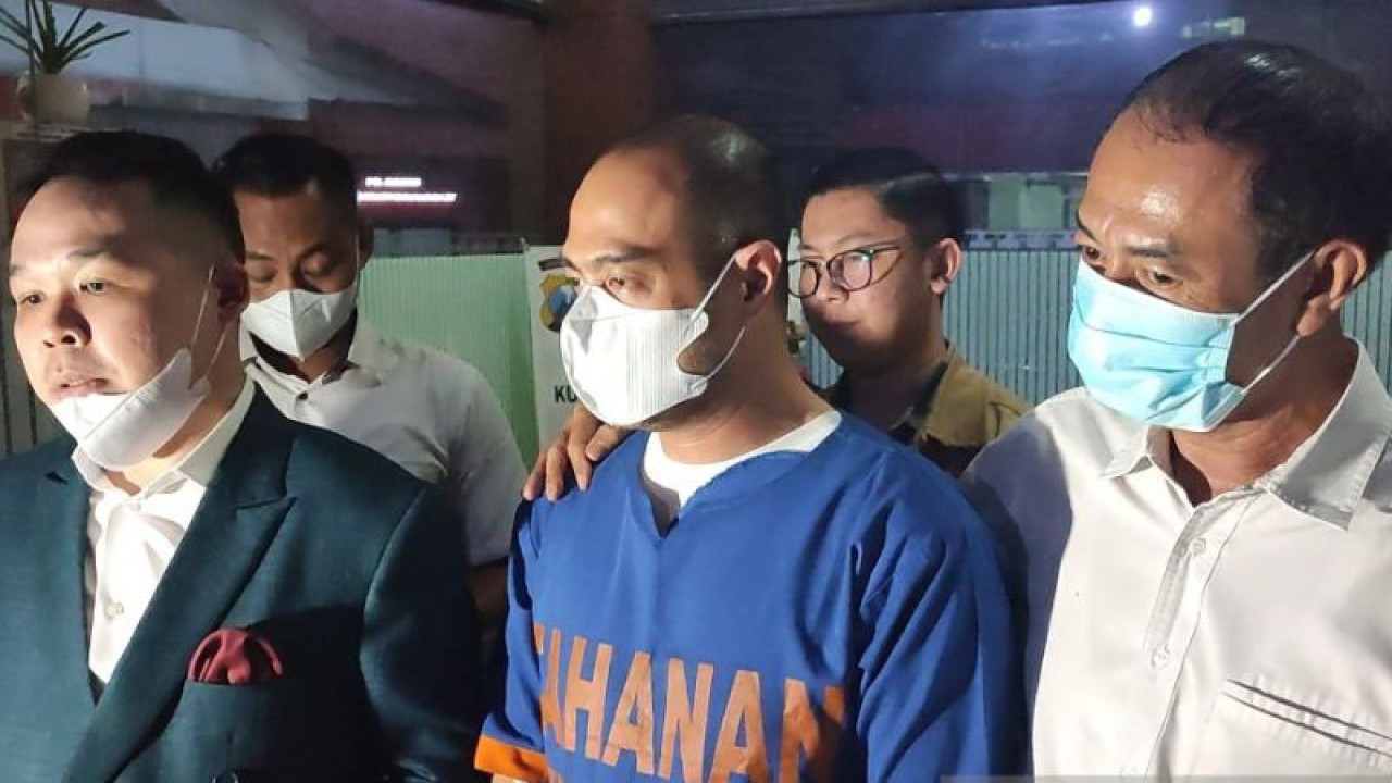 Artis Ferry Irawan (tengah) mengenakan baju tahanan usai menjalani pemeriksaan sebagai tersangka kasus KDRT di Mapolda Jatim, Surabaya, Senin (16/1/2023). (ANTARA/Willi Irawan)