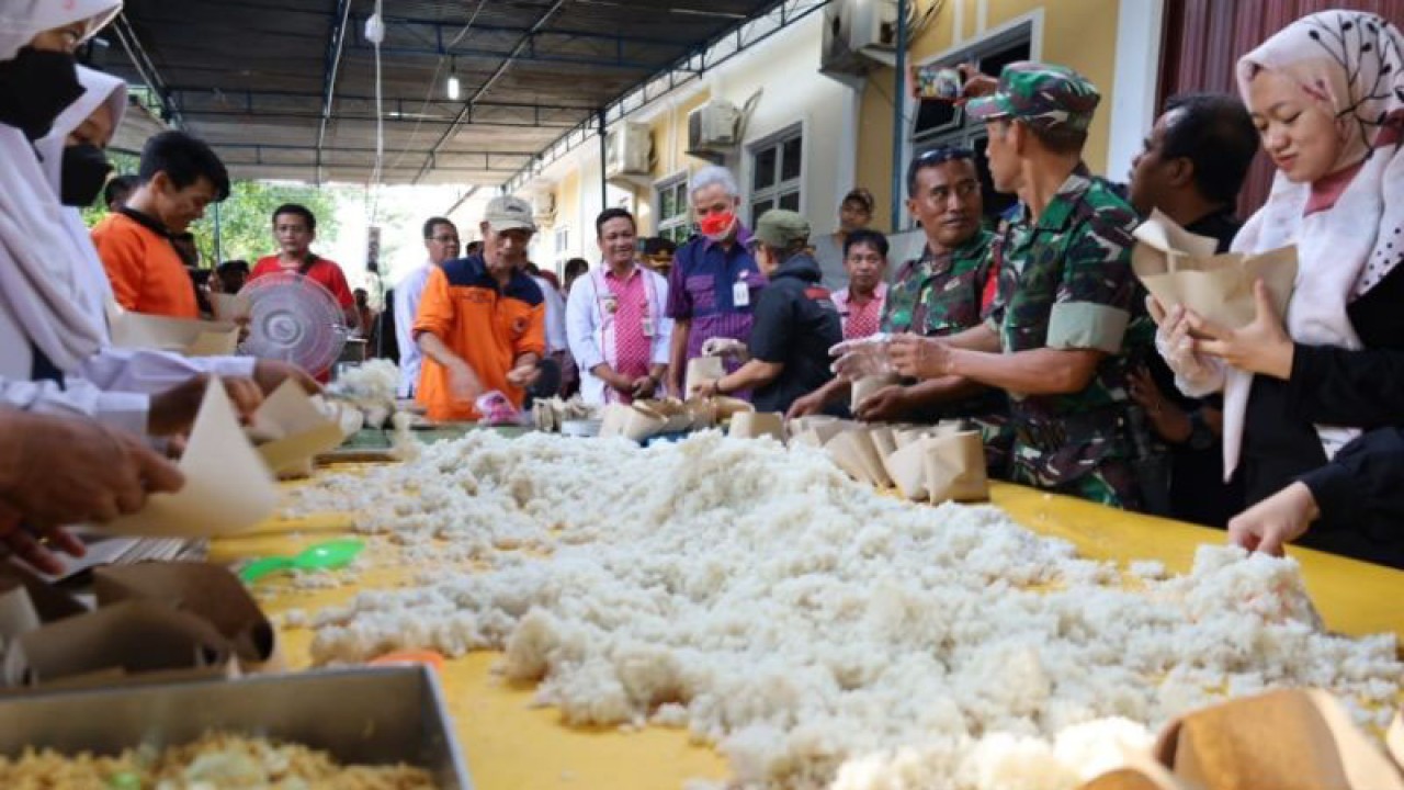 Gubernur Jawa Tengah Ganjar Pranowo (tengah) didampingi Wali Kota Pekalongan Afzan Arslan Djunaid meninjau dapur umum terpadu untuk memenuhi kebutuhan para pengungsi banjir, Selasa (3/1/2023). (ANTARA/Kutnadi)