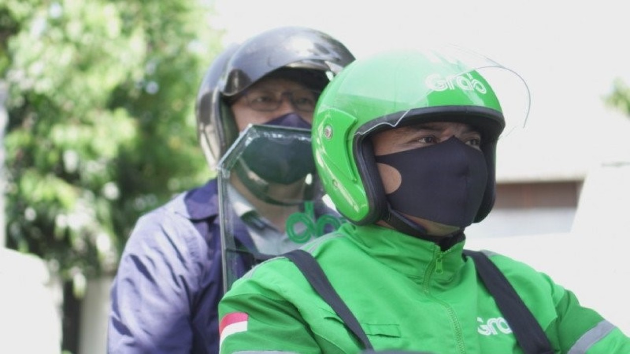 Pengemudi yang merupakan mitra Grab menggunakan partisi plastik sebagai pemisah untuk meminimalisir kontak antara penumpang dan mitra pengemudi guna mencegah penyebaran COVID-19. ANTARA Foto/HO/Humas Grab