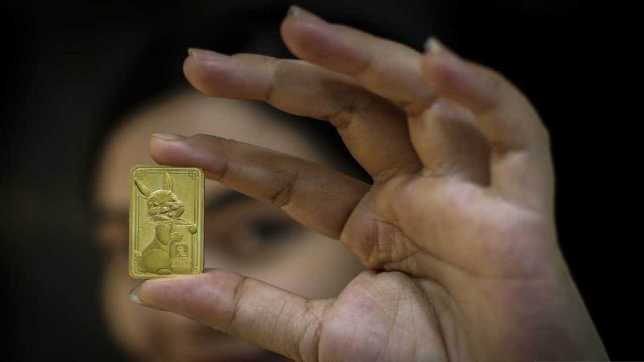 Petugas menunjukkan emas edisi imlek berupa gambar Kelinci di Butik Emas Antam, Setia Budi, Jakarta, Selasa (12/1/2023). Emas batangan edisi Imlek 2023 ini memiliki berat 8 gram dengan 99,99 persen emas murni dan dijual dengan harga Rp8,9 juta. ANTARA FOTO/Rivan Awal Lingga/hp.