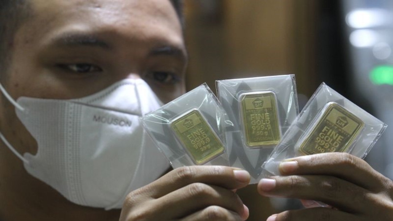 Karyawan menunjukkan emas batangan PT Aneka Tambang (Antam) di gerai emas dan perhiasan, Malang, Jawa Timur, Senin (12/12/2022). . ANTARA FOTO/Ari Bowo Sucipto/rwa (ANTARA FOTO/ARI BOWO SUCIPTO)