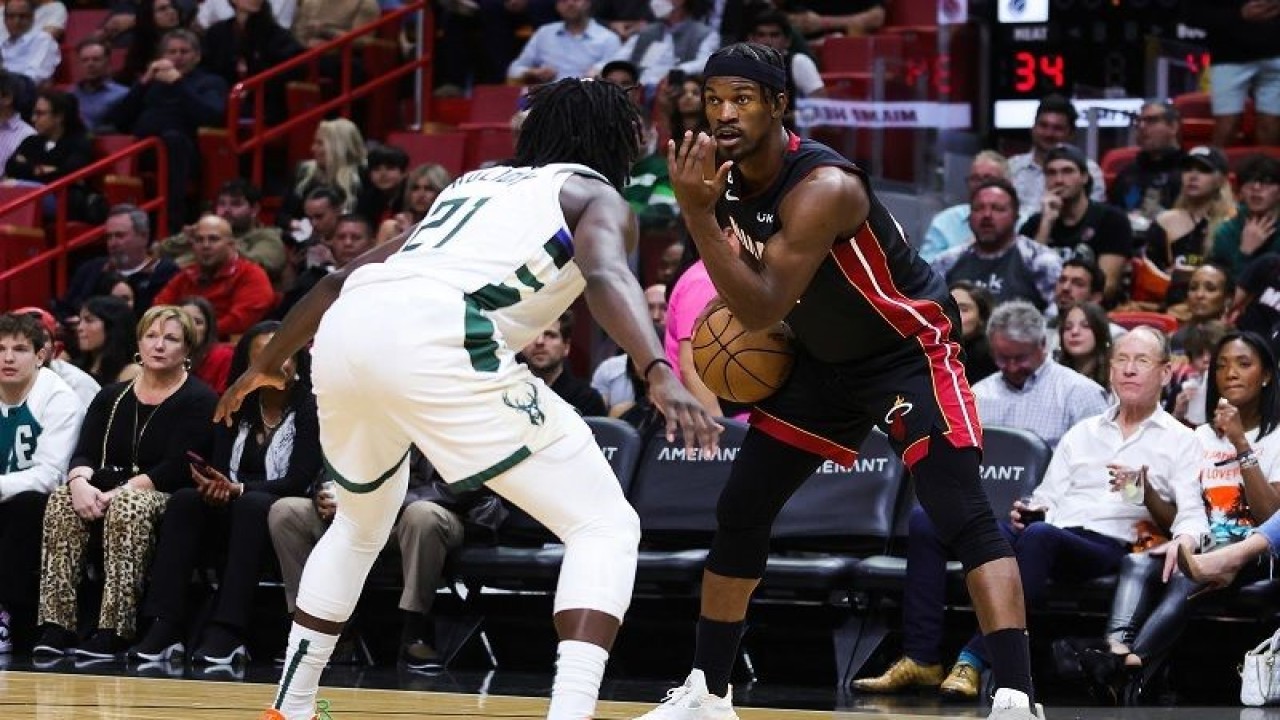 Bintang Miami Heat Jimmy Butler (kanan) berusaha memegang penguasaan bola di hadapan kawalan pemain Milwaukee Bucks Jrue Holiday dalam gim lanjutan NBA di FTX Arena, Florida, Amerika Serikat, Kamis (12/1/2023) waktu setempat. (ANTARA/AFP/GETTY IMAGES/Megan Briggs)