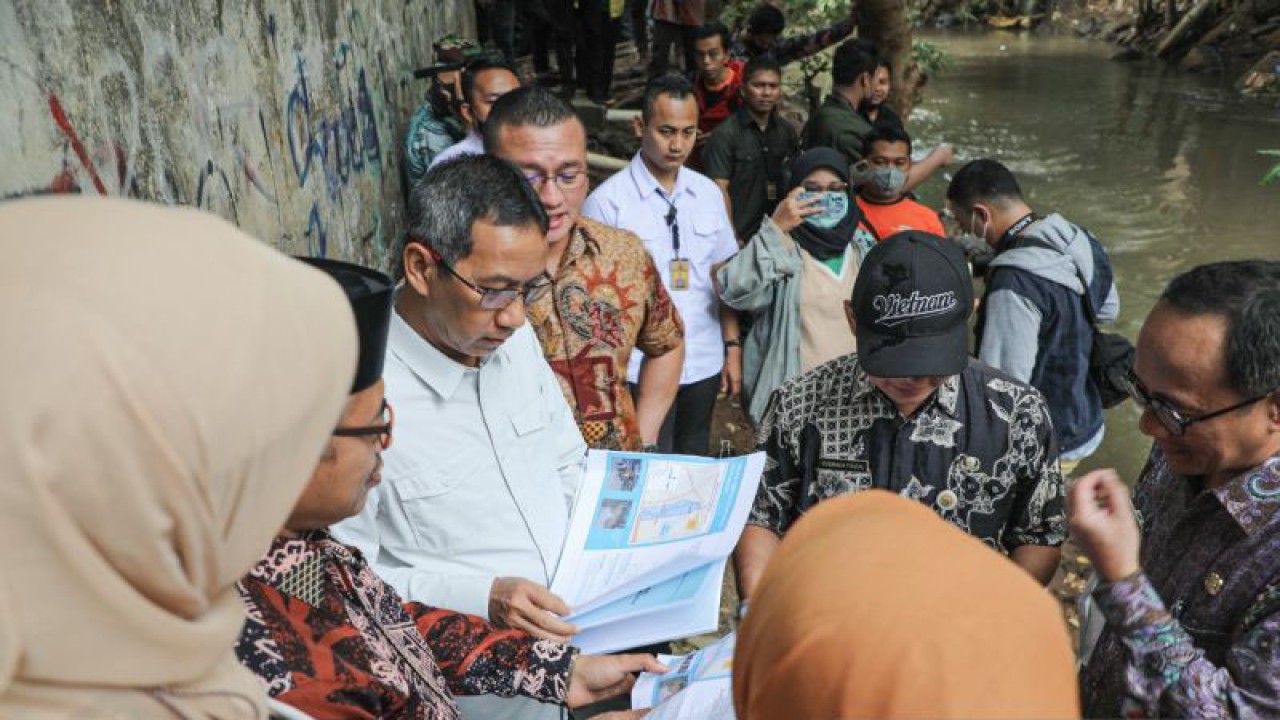 Penjabat Gubernur DKI Heru Budi Hartono (tengah) memeriksa data penanggulangan banjir di aliran sungai Pesanggrahan, Jakarta Barat, Kamis (19/1/2023). ANTARA/HO-Pemprov DKI