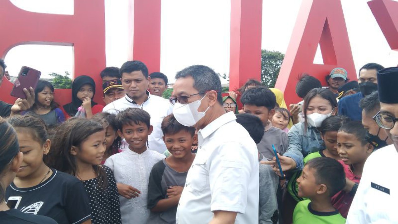 Penjabat Gubernur DKI Heru Budi Hartono bersama anak-anak di Tanggul Pantai Kalibaru di Jakarta Utara, Jumat (20/1/2023). ANTARA/Dewa Ketut Sudiarta Wiguna