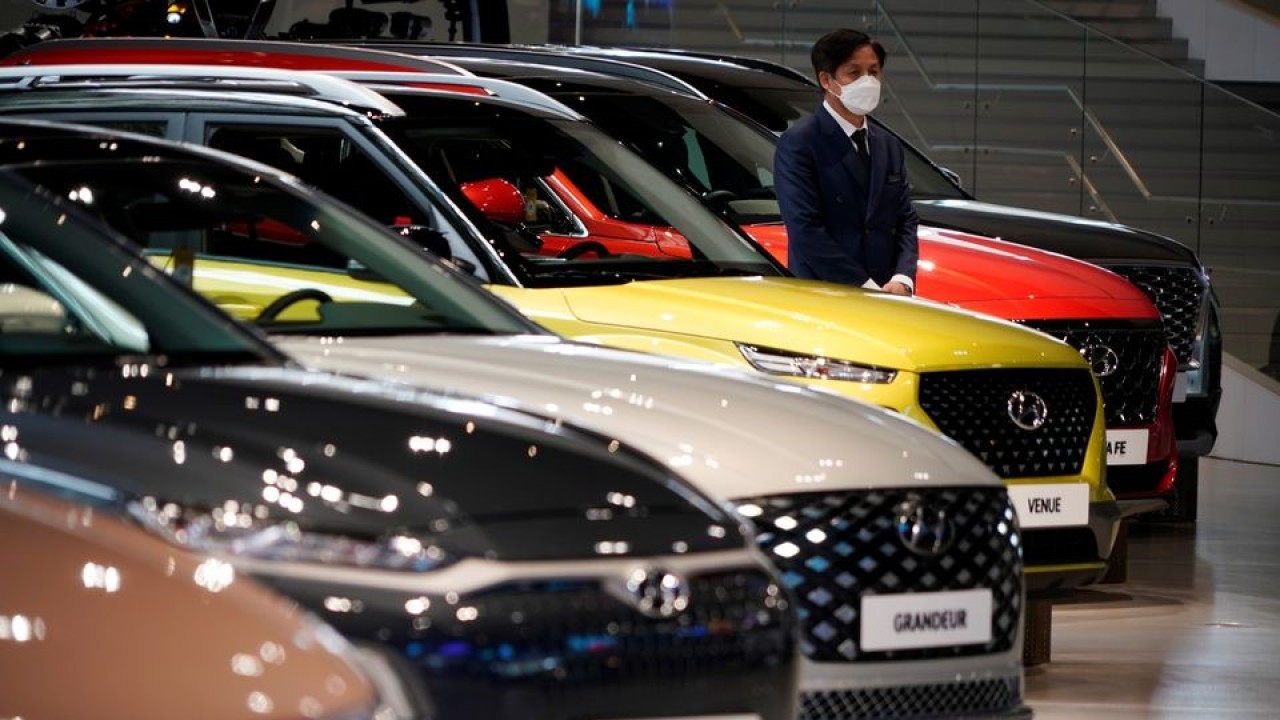 Seorang karyawan menunggu pelanggan di samping kendaraan Hyundai Motor di Hyundai Motor Studio di Goyang, Korea Selatan, 21 April 2020. (Kim Hong-Ji/Reuters)