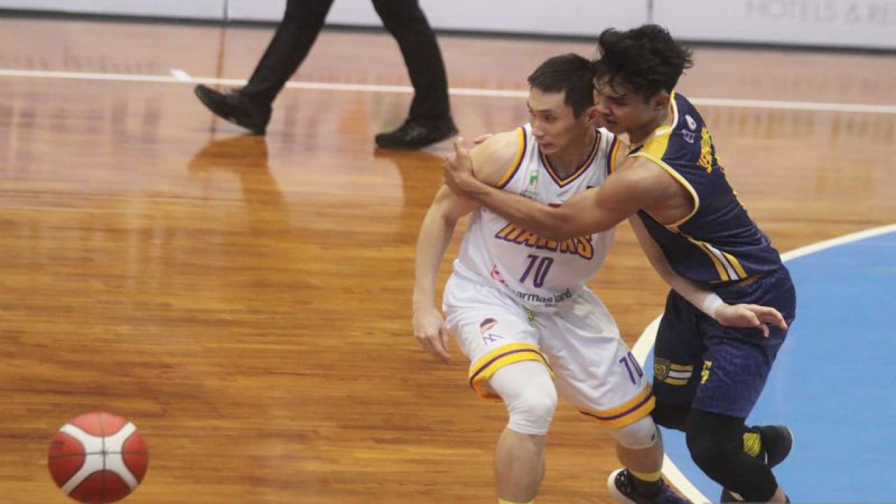 Salah satu pemain Satya Wacana Salatiga (kanan) menahan pemain Tangerang Hawks Basketball Club, pada pertandingan perdana seri kedua musim 2023 Liga Basket Indonesia (IBL), yang digelar di GOR Bimasakti, Kota Malang, Jawa Timur, Sabtu.  (ANTARA FOTO/Ari Bowo Sucipto)