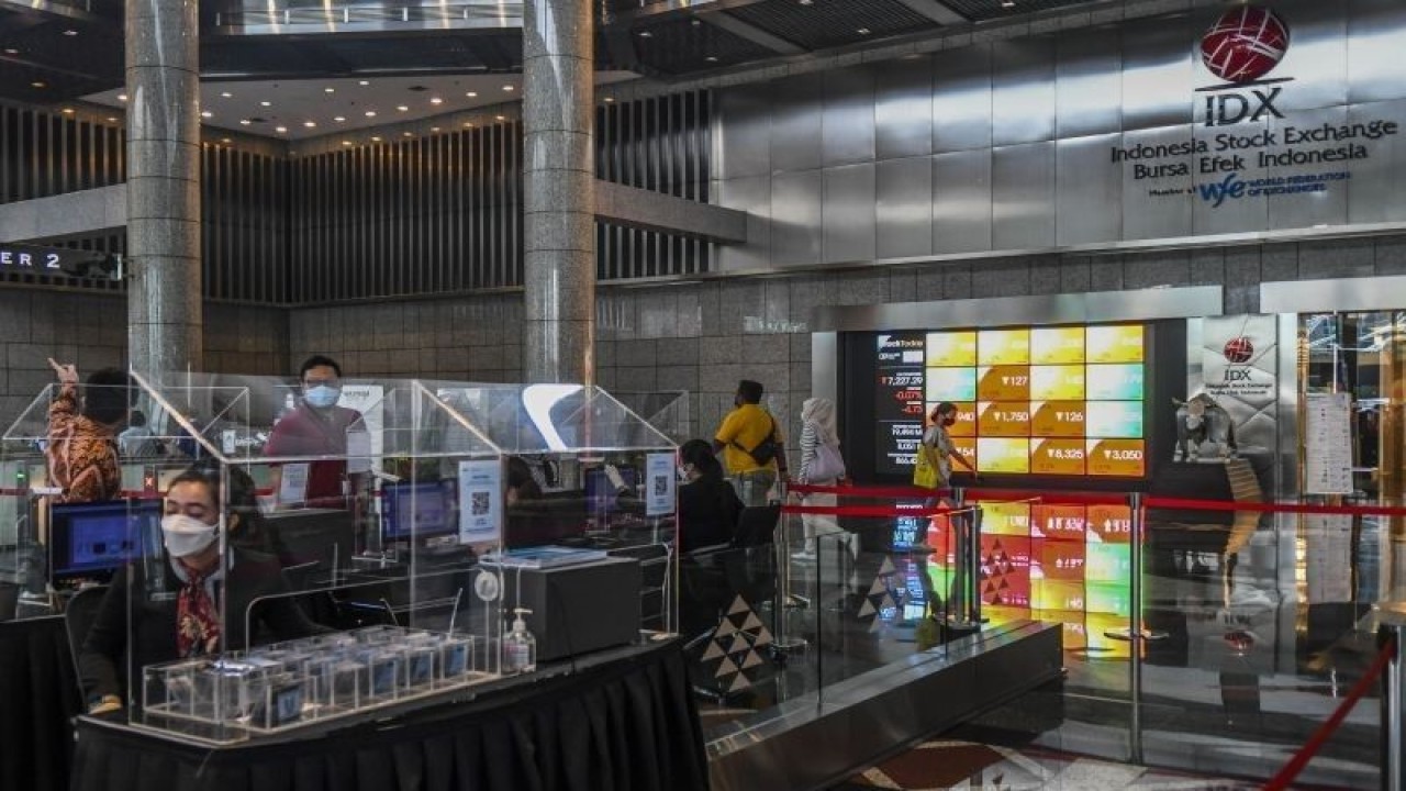 Karyawan melintas di samping layar elektronik yang menunjukkan pergerakan Indeks Harga Saham Gabungan (IHSG) di Bursa Efek Indonesia, Jakarta, Jumat (9/9/2022). ANTARA FOTO/Galih Pradipta/aww.