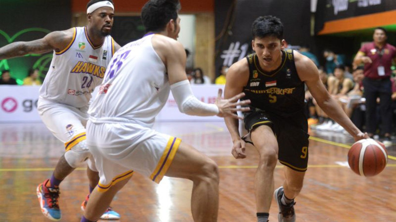 Pebasket Bima Perkasa Jogja Ikram Fadhil (kanan) berusaha melewati hadangan pebasket Tangerang Hawks Basketball Fabio Matheus Mailangkay (tengah) dan Tyron Lamar Criwsell (kiri) saat pertandingan Indonesian Basketball League (IBL) 2023 di GOR Merpati, Denpasar, Bali, Kamis (19/1/2023). ANTARA FOTO/Fikri Yusuf/nym (ANTARA FOTO/FIKRI YUSUF)