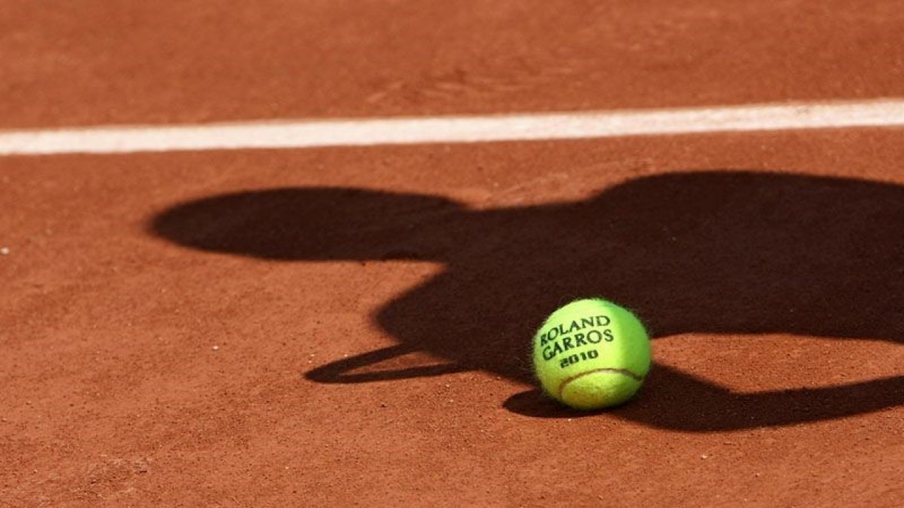 ilustrasi - Bola resmi turnamen tenis dengan bayang-bayang seorang pemain tenis diatas tanah. ANTARA/Shutterstock/pri.