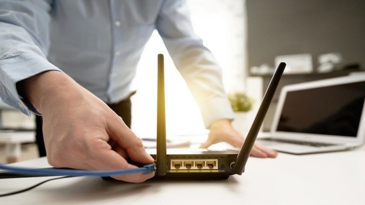 Ilustrasi - Seorang pria memasang kabel LAN router internet. (ANTARA/Shutterstock/am) (ANTARA/Shutterstock/am)